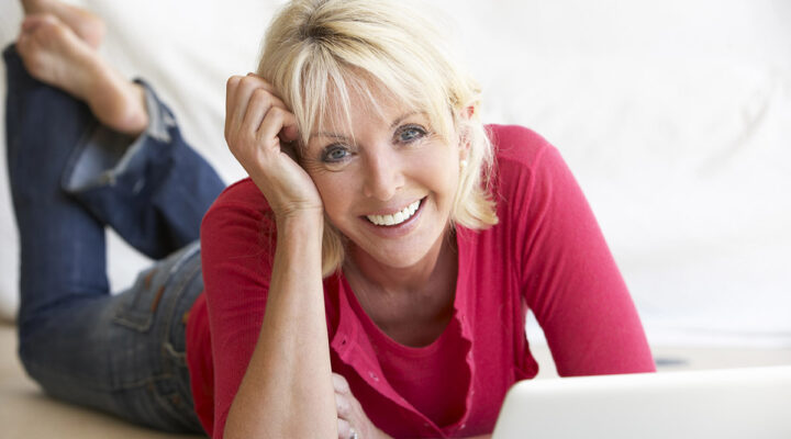 Middle age woman smiling with her laptop