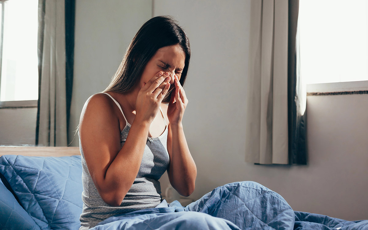 woman holding her nose with Sinus pain