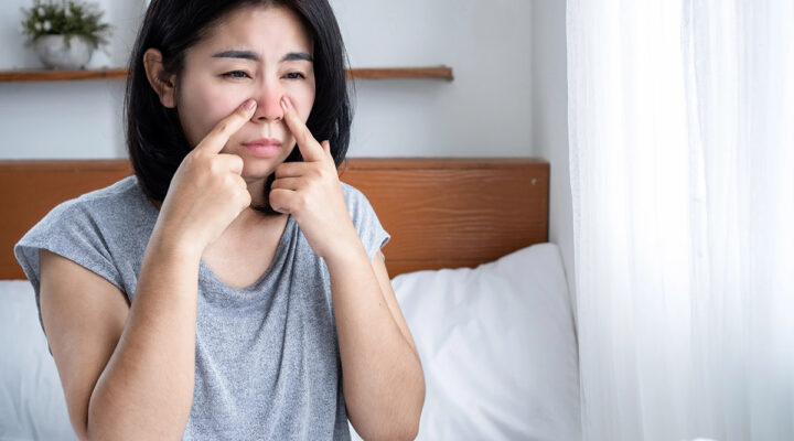 woman touching her nose with sinus