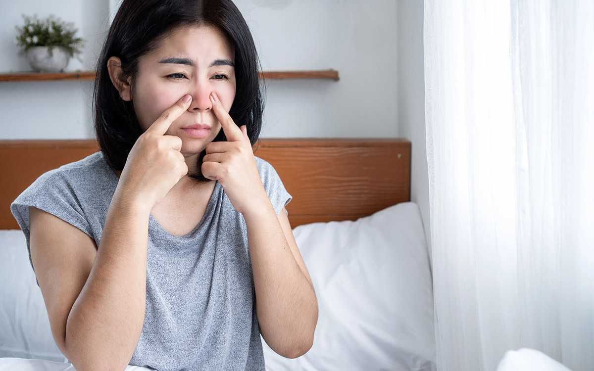 woman touching her nose with sinus